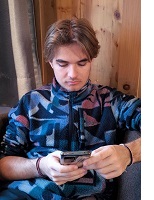 Junger Mann, der am Handy sitzt
